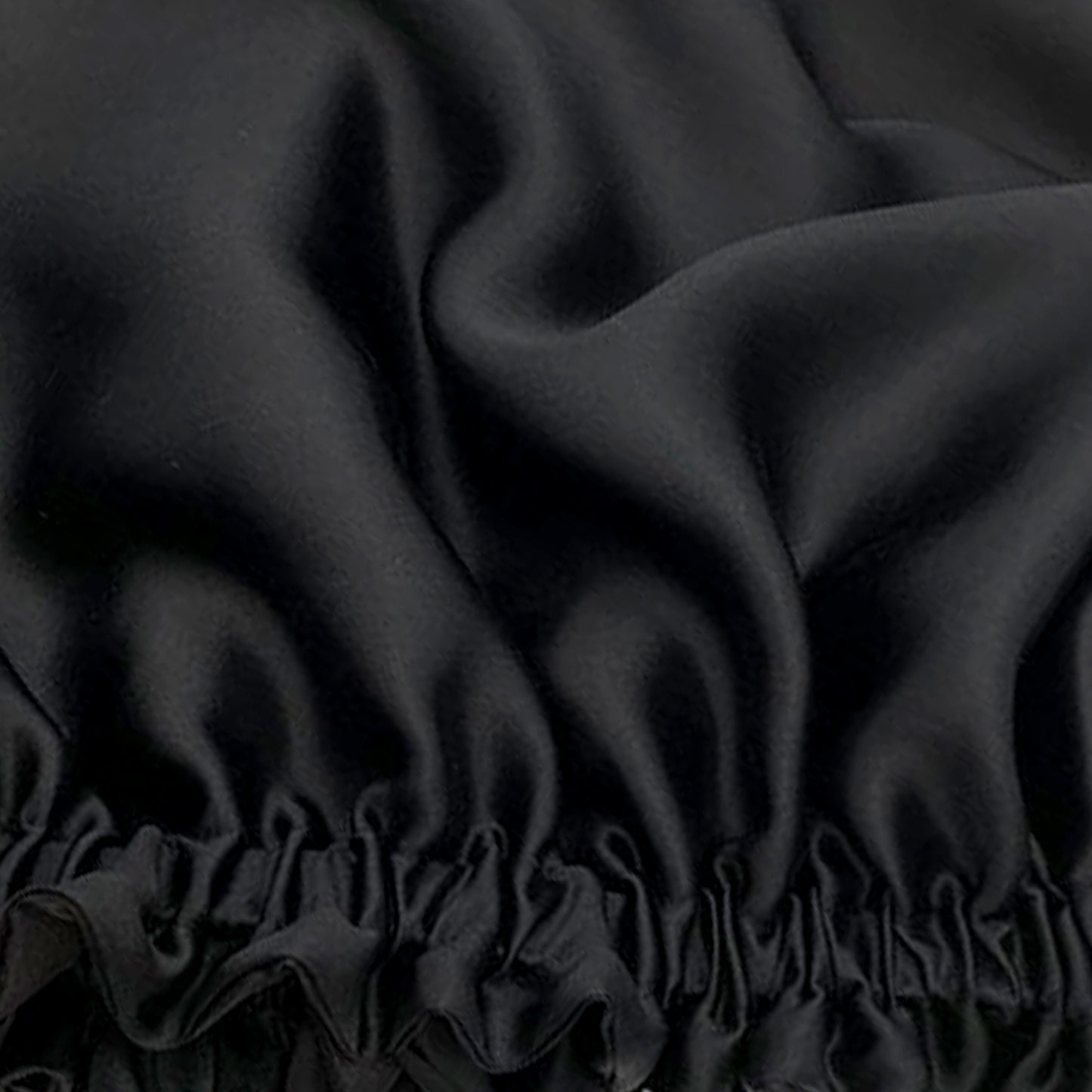 close up of the satin material used to make Evolve's black Onyx satin bonnet