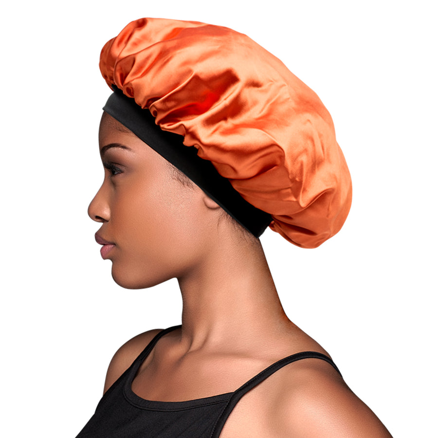 profile image of model wearing Evolve's orange satin bonnet with black elastic band